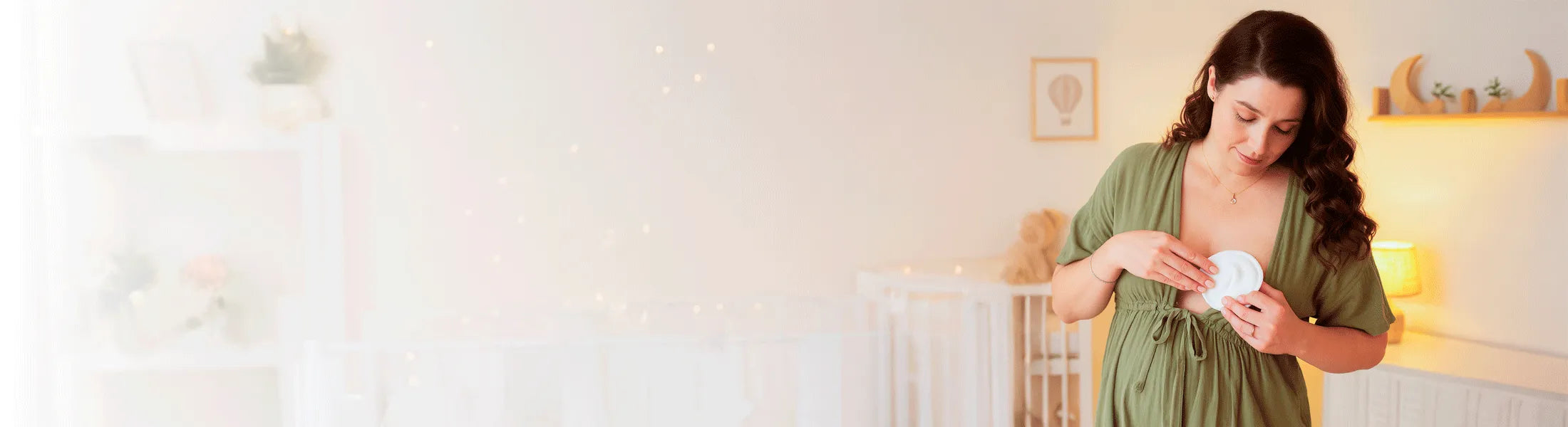 Banner absorbentes de leche reutilizables Pequelandia, mamá usando disco de lactancia en habitación infantil iluminada