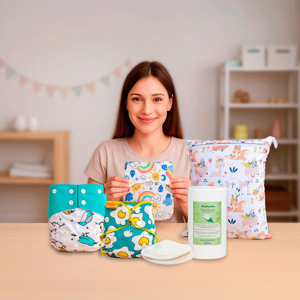 Mamá mostrando Pack Baby Shower con pañales ecológicos, wetbag, papel bambú y absorbentes de leche reutilizables Pequelandia sobre una mesa en dormitorio infantil