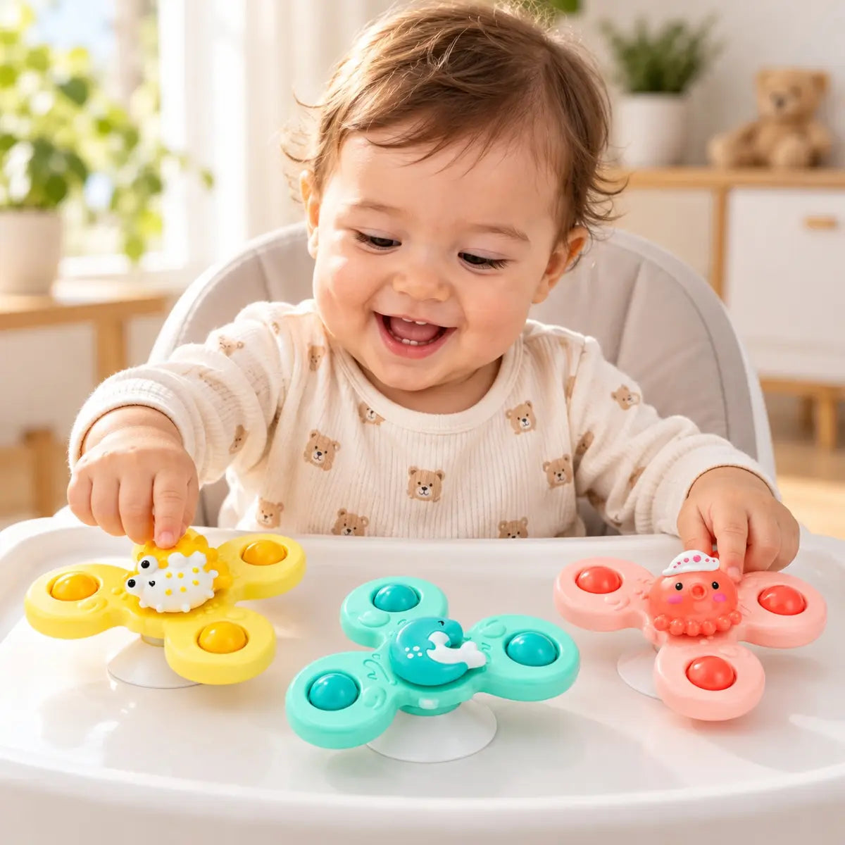 Bebé jugando con spinners con ventosa de colores sobre superficie lisa